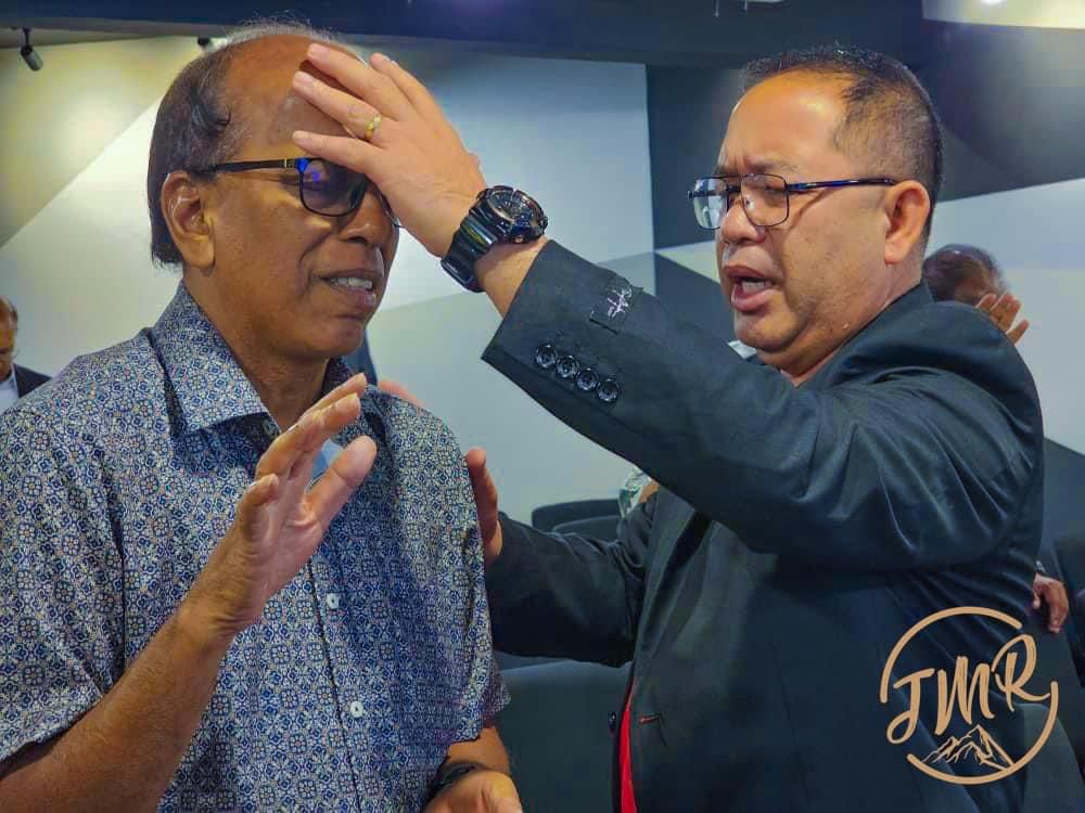 Rev Romed from Philippines lay hand to pray for a person