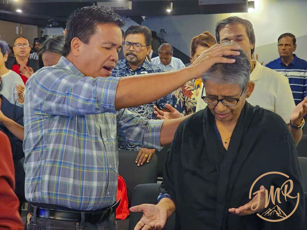 Rev Rener is praying for a person
