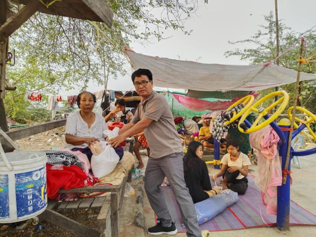 Handing food to victims in their makeshift homes