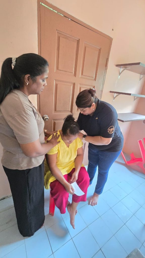 Members of the team praying for OA sister after medical session